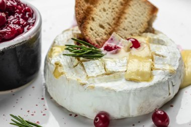 Koyu masada, kızılcık, fesleğen ve biberiye ile pişirilmiş peynirli camembert peyniri. Fransız mutfağı. metin için yer, üst görünüm.