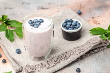 blueberry yoghurt shake in glass jar on a light background, place for text, top view,