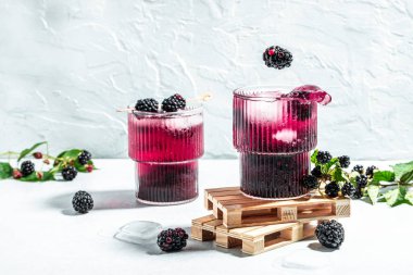 Blackberry mojito or lemonade with blackberry and ice Freeze motion splash drops on a light background. place for text.