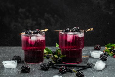 Refreshing lemonade with blackberry on a dark background. Long banner format.