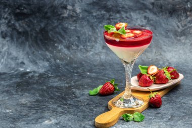 Mavi arka planda çilek soslu panna cotta vanilya. Metin için boşluk.