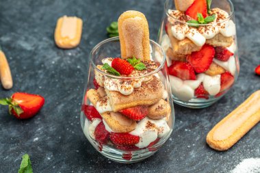 Tiramisu. Taze çilekli ev yapımı tiramisu, badem ezmesi ve koyu arkaplanda nane şekeri. Vegan laktozsuz tatlı, sağlıklı organik çökelti tarifi..