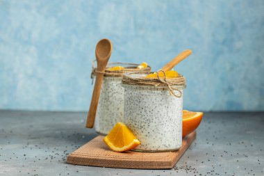 Narenciye ile süslenmiş camda laktozsuz yoğurt ile Chia Seed. Gri arka planda chia tohumlu yoğurt. sağlıklı süper yiyecekler. Sağlıklı yiyecekler. metin için yer.