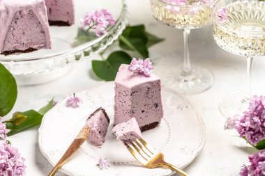 mousse cake blueberry tart. bouquet of purple blooming lilacs, French cuisine, postcard, background.