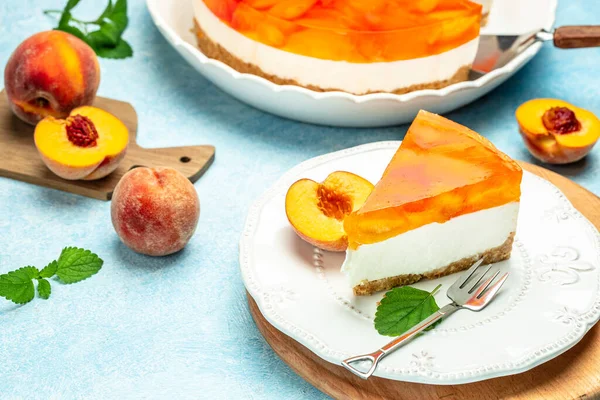 Layered cheesecake piece with peaches, peache jelly, jam. delicious sweet dessert piece of cheesecake. Homemade cream cake with peaches,