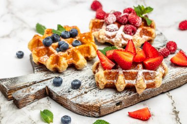 Ahududu, çilek ve yabanmersinli Belçika Waffle 'ı. Mutfak, yemek pişirme, fırın konsepti. Yemek tarifi geçmişi. Kapat..