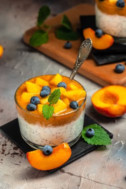 Healthy chia pudding with yogurt and fruit Peach and blueberry. Homemade dessert with fruits. place for text, top view.