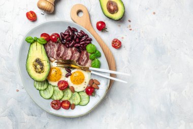 Ketogenik diyet öğün avokado, kızarmış yumurta, pastırma ve fasulye. Sağlıklı besleyici paleo keto kahvaltı diyeti öğle yemeği. Pankart, yemek servisi menü tarifi yeri, metin, üst görünüm.