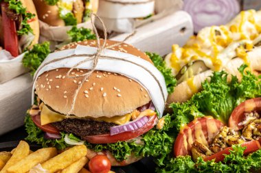 Ev yapımı hamburgerler, ızgara et, sebze ve ahşap arka planda patates kızartması. Fast food ve abur cubur kavramı.