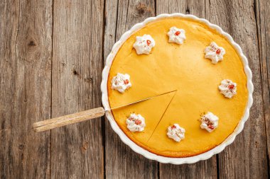 Homemade pastry for Thanksgiving traditional Pumpkin Pie with whipped cream. Long banner format. top view.