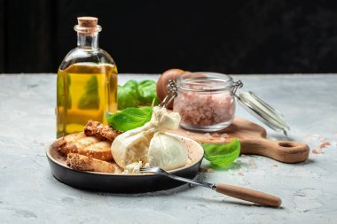 fresh soft white burrata cheese ball made from mozzarella and cream from Apulia, Italian Mediterranean cuisine, place for text.
