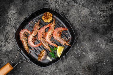 Baharatlı lezzetli karides, koyu bir arka planda dondurulmuş limon suyuyla kızartılmış karides. Deniz ürünleri aperatifi. Aşçılık, aşçılık konsepti.