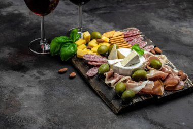 Antipasto tabağı İspanyol jamonu serrano ya da İtalyan prosciutto crudo, koyu arkaplanda İtalyan sert peynirli pecorino toscano. en üstteki görünüm.
