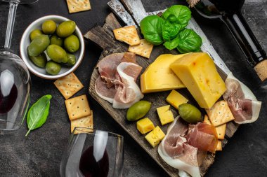 Dilimlenmiş et, jambon, salam, peynir, zeytin ve şaraplı Antipasto tahtası.,