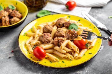 Köfteli makarna ve sarı tabakta domates sosu ve gri arka plan. Mutfak, yemek pişirme, fırın konsepti, afiş, metin için menü tarifi yeri, üst görünüm,