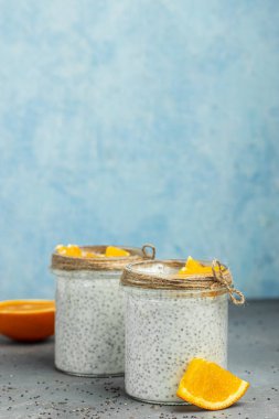 Portakallı puding. Chia tohumlu yoğurt sağlıklı süper yiyecek. Cam kavanozlarda süzme peynirli smoothie. metin için yer.