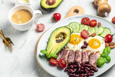 Avokado, sahanda yumurta, pastırma ve fasulyeyle Keto kahvaltısı. Paleo Keto kahvaltı diyeti öğle yemeği. Sağlıklı besleyici paleo keto kahvaltı konsepti. Yemek tarifi geçmişi. Kapat.,