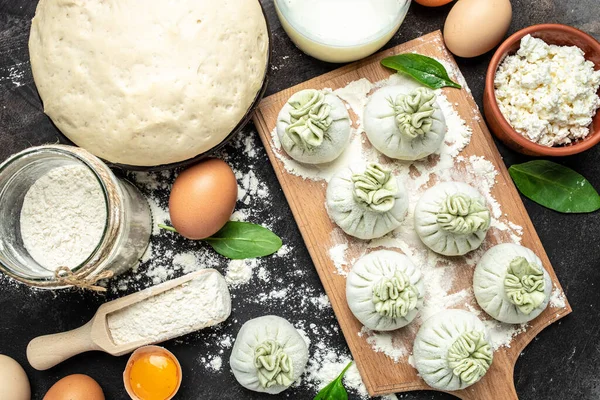 Peynirli ve ıspanaklı Gürcü hamur tatlısı. Çiğ, yarı bitmiş meyveli börekler. afiş, menü, metin için tarif yeri, üst görünüm.