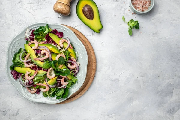 Taze avokado salatası, karides, marul yeşili karışım ve zeytinyağı, limon sosu. Sağlıklı yemek, lezzetli kahvaltı ya da atıştırmalık, temiz yemek, diyet, vejetaryen yemek konsepti. en üstteki görünüm.