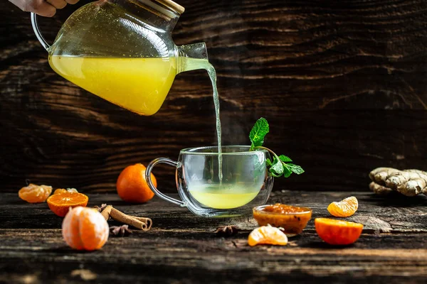 Citrus tea with lemon, yellow fruit tea with sea buckthorn and tangerines, Glass of fresh drink fruit tea with mint and honey. place for text.