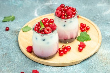 Raspberry dessert cheesecake, trifle, mouse in a glass. Raspberry Greek yogurt granola parfait on a light background. Restaurant menu, dieting, cookbook recipe.