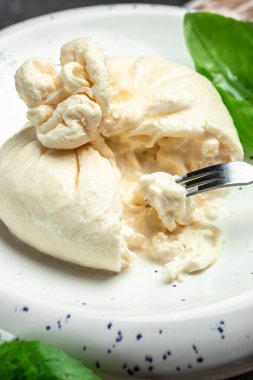 Mozzarella 'dan taze beyaz burrata peyniri ve Apulia' dan krema, İtalyan Akdeniz mutfağı, dikey görüntü. Üst Manzara. metin için yer.