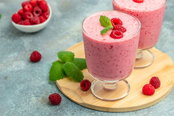 Ahududulu smoothie milkshake ya da böğürtlenli cam kavanozda yoğurt. Mavi arka planda yoğurt kokteyli. metin için yer, üst görünüm.