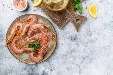 Seafood. Red Argentine shrimps with salt and lemon, Wild shrimps, ocean jumbo shrimps on a light background. banner, menu, recipe place for text, top view.