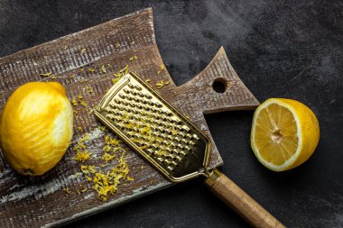 Rende kabuğu ve limon lezzeti siyah arka planda pişmeye hazır, uzun afiş biçimi. en üstteki görünüm.