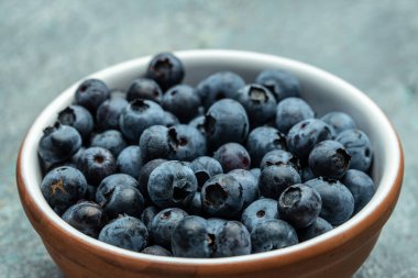 Masanın üzerinde taze, olgun yaban mersini kasesi var. afiş, menü, metin için tarif yeri, üst görünüm.