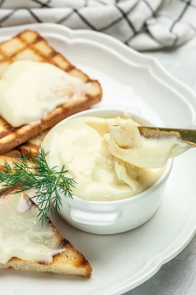 cream cheese and butter for breakfast. melted cheese on light background. vertical image. place for text.