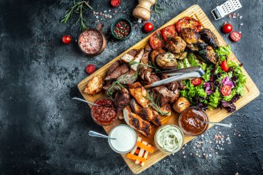 Lezzetli ızgara et ve sebze. Ahşap tabakta ızgara bbq eti ve sebzeler. Restoran menüsü, diyet, yemek kitabı tarifi üst görünümü,