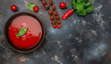 Arka planda fesleğenli domates çorbası. Uzun afiş biçimi. en üstteki görünüm.