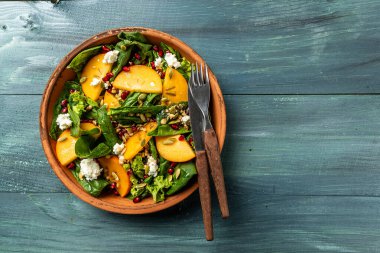 Vejetaryen menüsü, sağlıklı yiyecekler. Hurma, ıspanak, fındık, keçi peyniri, nar ve balkabağı tohumlu sağlıklı salata. Vitamin eksikliğinin önlenmesi.