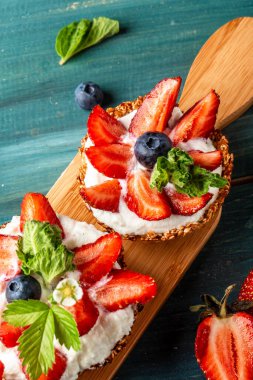 Kremalı, çilekli ve yabanmersinli meyveli tartlar. Metin için pankart menüsü tarifi yeri.