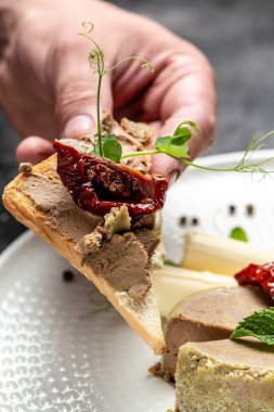 Erkek elleri kızarmış ekmeğe ev yapımı macun sürer. Taze ev yapımı börek. Karaciğer ezmesi. Lezzetli dengeli gıda konsepti.
