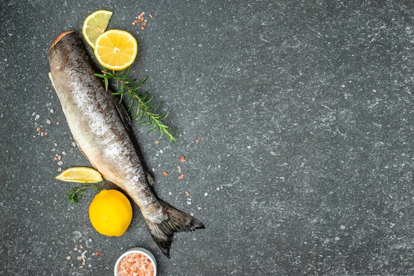 Fresh raw salmon red fish, Raw fish trout steak with spices and herbs on dark slate table. place for text, top view.