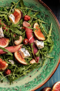 Lezzetli gurme salatası, dilimlenmiş taze incir ve üzümlerle servis edilen yumuşak peynir çeşitleri, dikey görüntü. en üstteki görünüm.