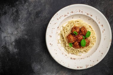 Köfteli spagetti makarna ve arka planda domates sosu. Restoran menüsü, diyet, yemek kitabı tarifi üst görünümü.
