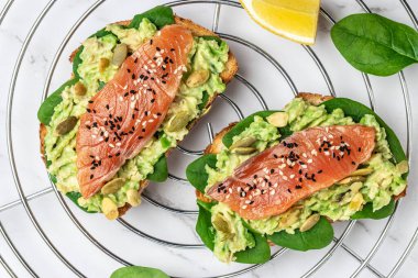 Avokado ezmeli ve somonlu tam tahıllı ekmek. Keto Paleo diyeti. Restoran menüsü, diyet, yemek kitabı tarifi üst görünümü.