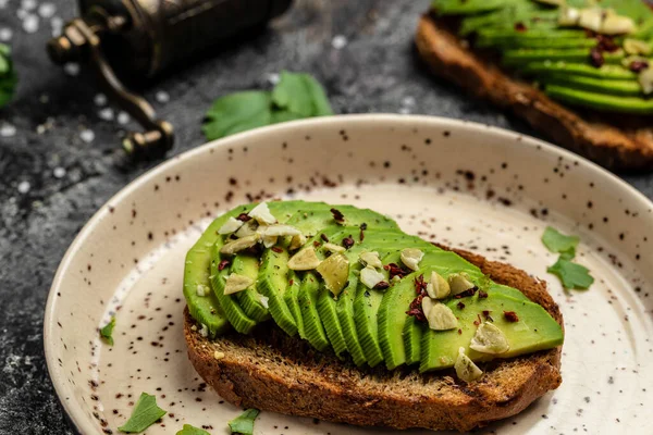 toasts with avocado, rye bread, sliced avocado. Vegetarian Vegan menu, recipe. Delicious breakfast or snack, Clean eating, dieting, vegan food concept. top view.