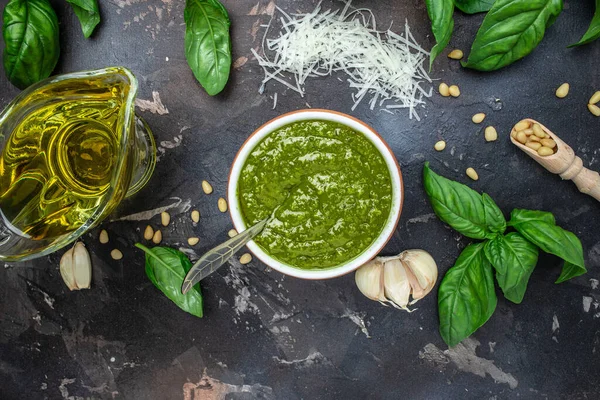 Italian basil pesto sauce bowl with green pesto pine nuts, parmesan and garlic. place for text, top view.