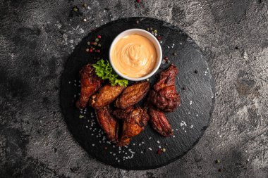 Barbekü tavuk kanadı, koyu arkaplanda soslu fırında tavuk kanadı. afiş, menü, metin için tarif yeri, üst görünüm.