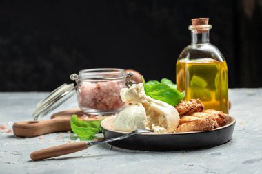 fresh soft white burrata cheese ball made from mozzarella and cream from Apulia, Italian Mediterranean cuisine, place for text.