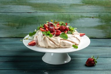 Lezzetli ev yapımı Pavlova pastası taze çilek ve krem şantili. Kadın fırıncı nefis kremalı pasta dekorasyonu, üst manzara. metin için yer,
