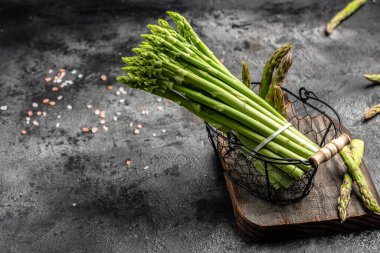 Koyu arkaplanda bir sürü taze kuşkonmaz, yeşil kuşkonmaz turşusu. metin için yer, üst görünüm.