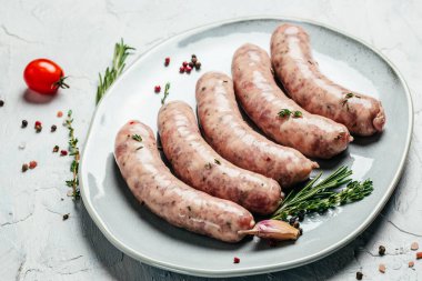 Baharatlı ve biberiyeli çiğ sosis. Yemek malzemesi. Doğal sağlıklı gıda konsepti. Yemek tarifi geçmişi. Kapatın. en üstteki görünüm,