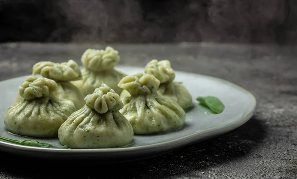 Hot Khinkali with cheese and spinach. Restaurant menu, dieting, cookbook recipe top view.
