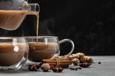 Siyah arka planda süt ve baharatlı sıcak Hint masala çayı. afiş, menü, metin için tarif yeri.