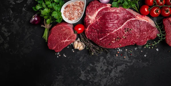 Beef tenderloin fillet with rosemary and spices on a dark background. Preparing fresh beef steak ready to cook. top view.